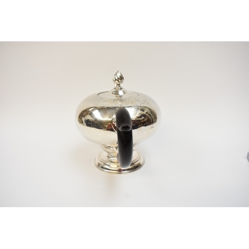 5003 - A George II silver pedestal ogee-shaped teapot, with foliate-chased shoulders, engraved crest, and e... 