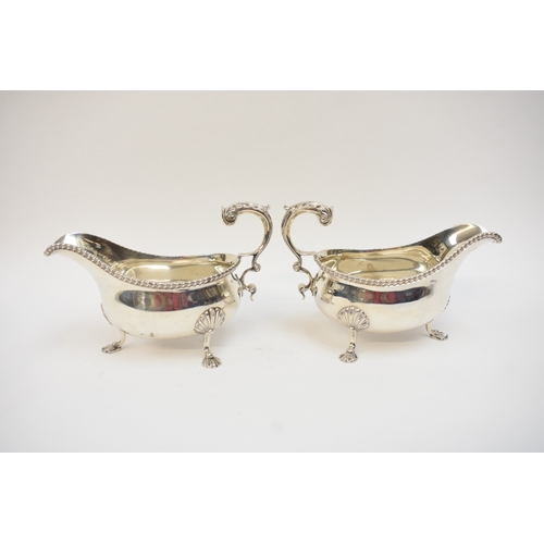 5020 - A pair of Edwardian silver sauce boats in the George III style, with gadrooned rims and flying 
