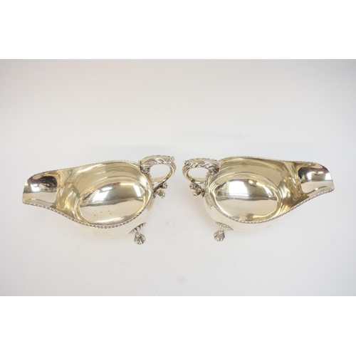 5020 - A pair of Edwardian silver sauce boats in the George III style, with gadrooned rims and flying 