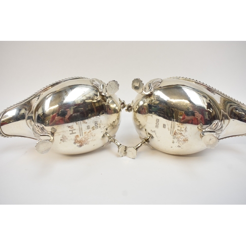 5020 - A pair of Edwardian silver sauce boats in the George III style, with gadrooned rims and flying 