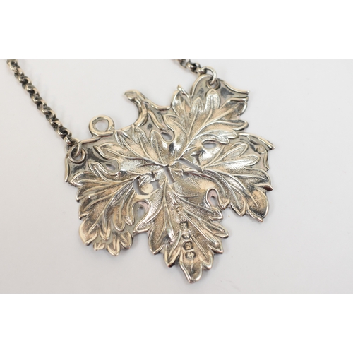 5058 - An early Victorian repousse silver decanter label in the form of a vine leaf, with pierced letters 