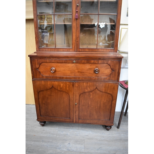 4047 - A Circa 1860 flame mahogany bookcase on base, the cushioned pediment over two astragal glazed doors ... 
