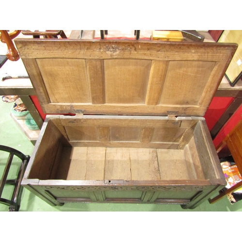 4018 - An 18th Century three panel pegged oak coffer the rising lid over a carved front and channeled munti... 