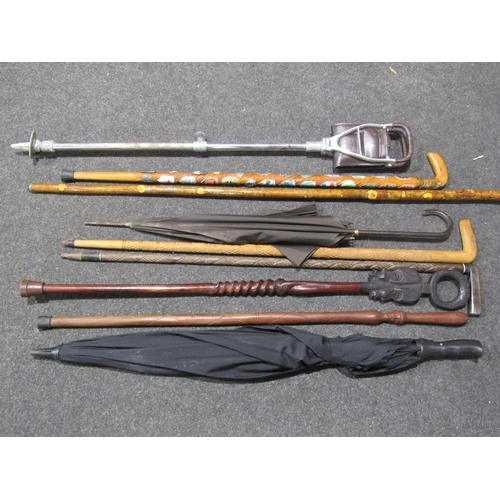 1035 - A selection of carved walking sticks including Eastern examples, shepherd's stick, a shooting stick ... 