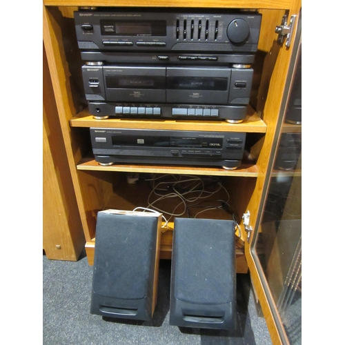 1029 - A cabinet containing a collection of Sharp stereo equipment to include tape and CD player