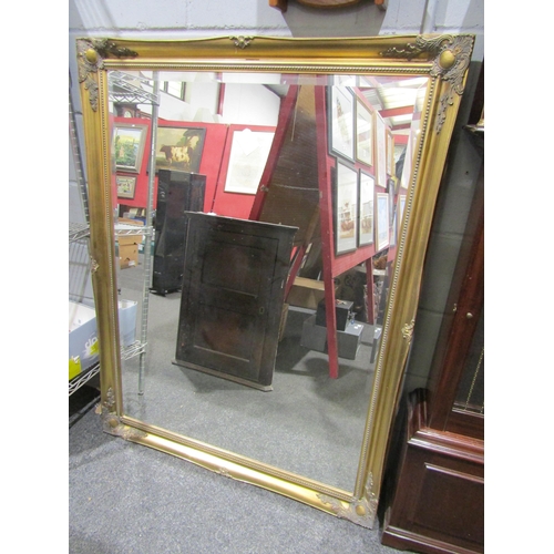1054 - A reproduction gilt framed wall mirror, bevelled glass, 137cm x 106cm total