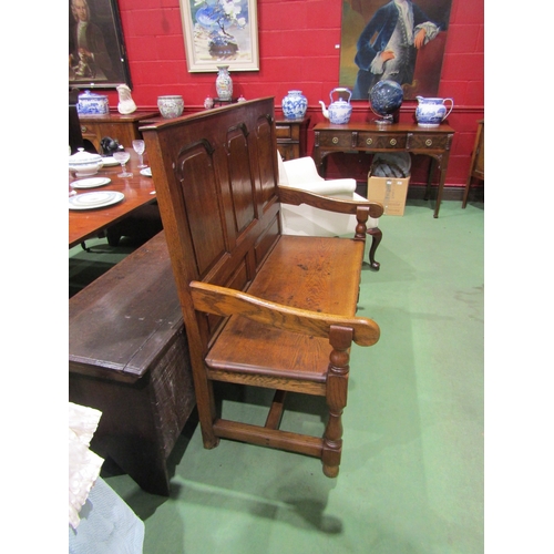 4003 - A 17th Century revival oak three panel back hall settle the scroll arms on turned supports united by... 