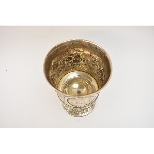 6006 - A Georgian silver wine goblet with embossed floral cartouches, decorative border, central monogramme... 