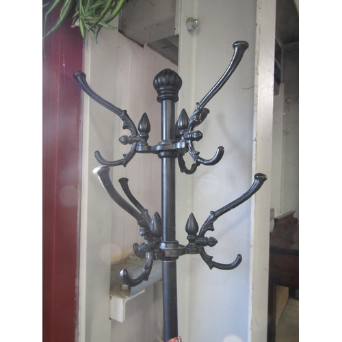 A cast iron coat rack with stick stand