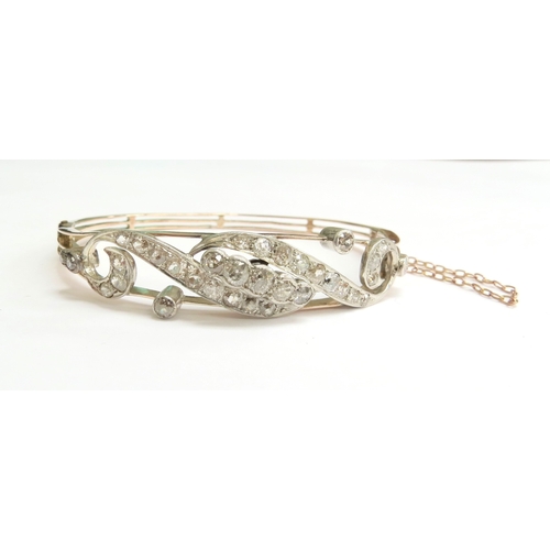 7059 - A diamond set hinged bangle with 35 various sized rose cut diamonds, unmarked, 6cm x 5cm, 16g