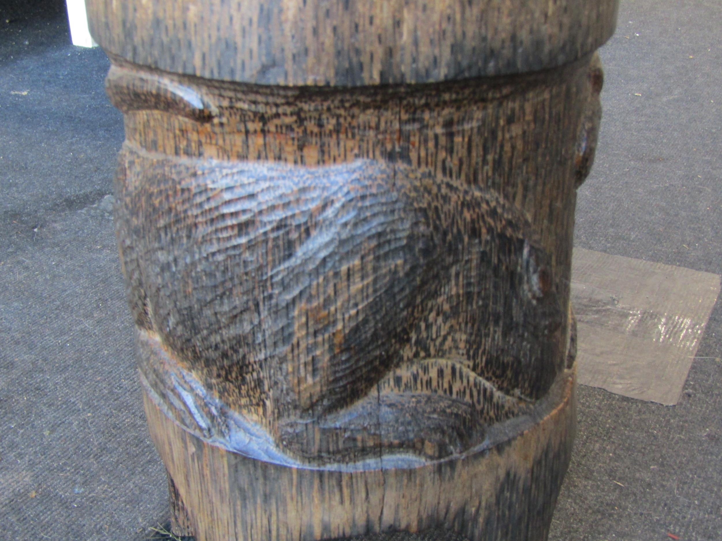 A carved wooden five legged stool with big cats to side panel and ...