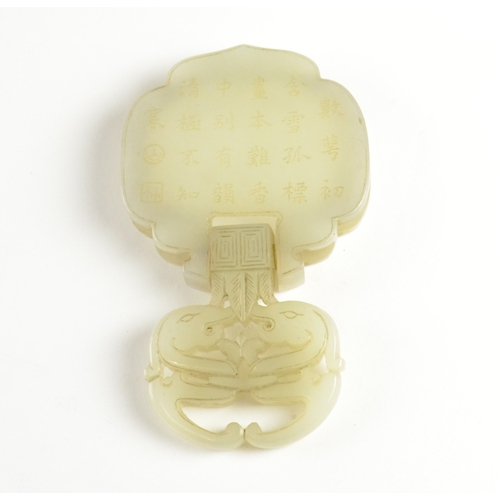 9021 - A Chinese pale celadon belt fitting in the form of two dragons to the front, the reverse inscribed w... 