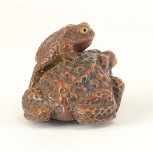 9060 - RISUI: a carved wooden toad with baby on its back, inlaid horn eyes, signed to base

4.2cm wide, 3.2... 