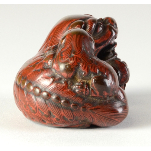9048 - A lacquered negoro netsuke of a shishi with baby on back, holding a ball in front paws

4cm wide x 3... 