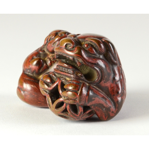 9048 - A lacquered negoro netsuke of a shishi with baby on back, holding a ball in front paws

4cm wide x 3... 