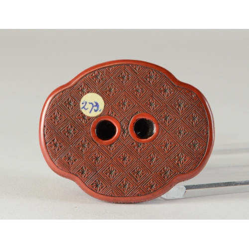 9045 - A red lacquered netsuke in the form of two shishi wrapped around a ball, flat base

3.8cm wide x 3.4... 