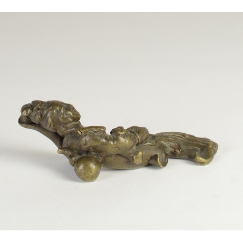 9027 - A Chinese bronze scroll weight in the form of a recumbent lady holding a ruyi sceptre

7.7cm wide, 3... 