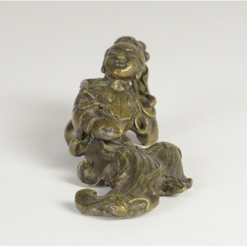 9027 - A Chinese bronze scroll weight in the form of a recumbent lady holding a ruyi sceptre

7.7cm wide, 3... 