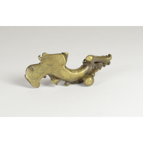 9027 - A Chinese bronze scroll weight in the form of a recumbent lady holding a ruyi sceptre

7.7cm wide, 3... 