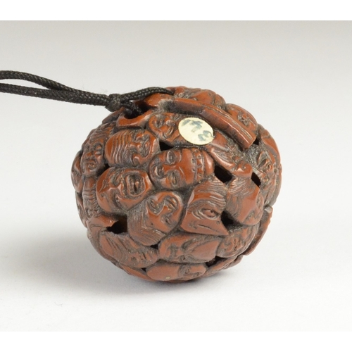 9050 - A carved nut featuring approximately fifty noh masks to include Kitsune, Oni, Okina, Ko-Omote and Ch... 