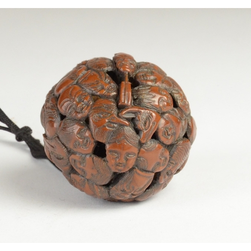 9050 - A carved nut featuring approximately fifty noh masks to include Kitsune, Oni, Okina, Ko-Omote and Ch... 