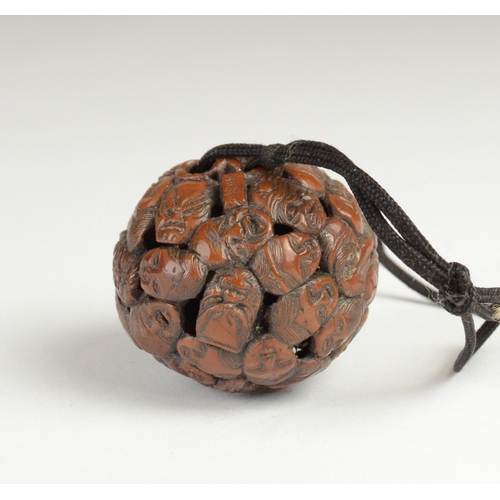 9050 - A carved nut featuring approximately fifty noh masks to include Kitsune, Oni, Okina, Ko-Omote and Ch... 