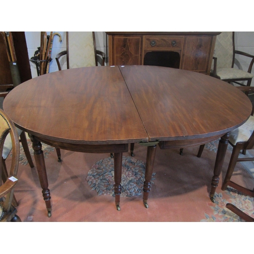 1021 - A 19th Century mahogany dining table comprising two D-end sections, raised on turned supports to cas... 