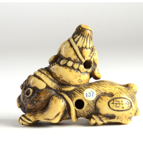 9036 - TOZAN-A stag's horn netsuke of Monju Bosatsu on a lion's back, playing the flute- signed Tozan in ov... 