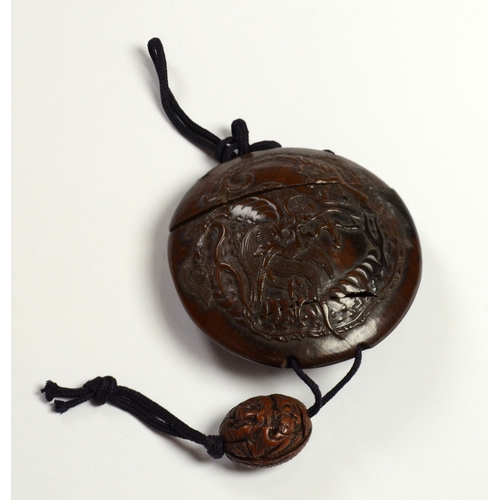 9013 - A circular single case inro carved in relief with dragon and carved ojime bead 

5.6cm diameter

Pro... 