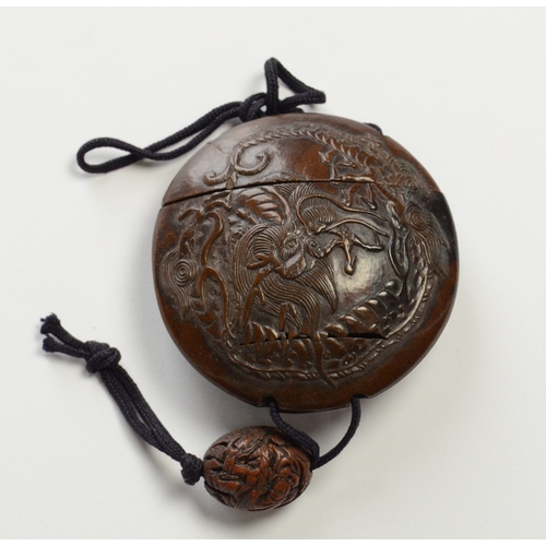 9013 - A circular single case inro carved in relief with dragon and carved ojime bead 

5.6cm diameter

Pro... 