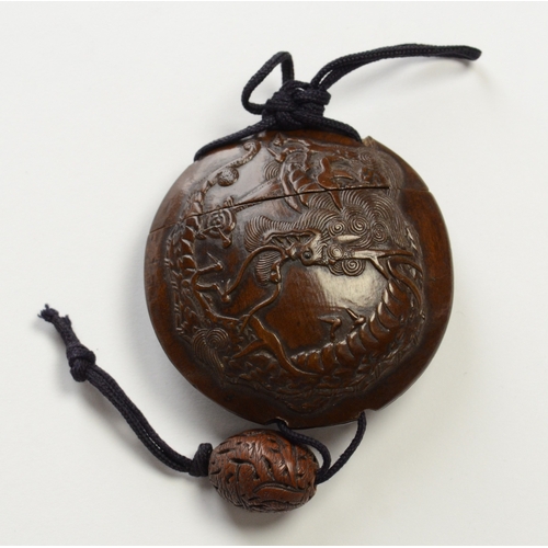9013 - A circular single case inro carved in relief with dragon and carved ojime bead 

5.6cm diameter

Pro... 