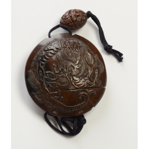 9013 - A circular single case inro carved in relief with dragon and carved ojime bead 

5.6cm diameter

Pro... 