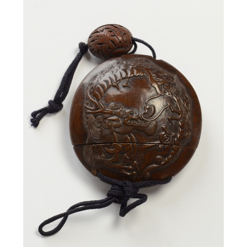 9013 - A circular single case inro carved in relief with dragon and carved ojime bead 

5.6cm diameter

Pro... 