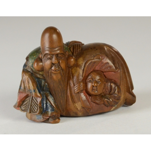 9051 - SHUZAN a wooden and partially lacquered netsuke depicting Fukurokuju with Hotei in his bag, signed t... 