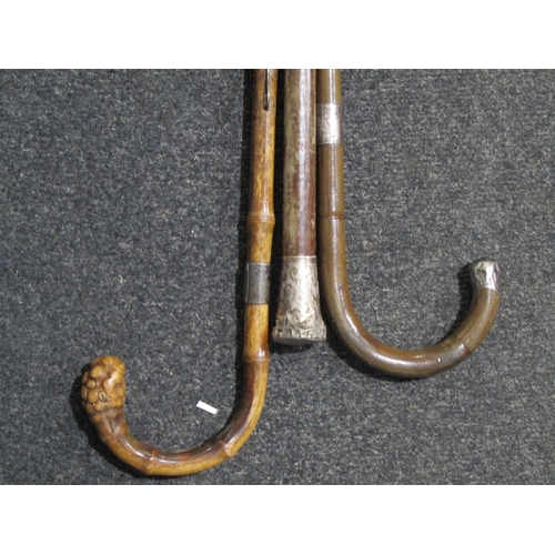 1038 - A bundle of walking sticks with shooting stick and hanger, two with silver handles and bands (5)