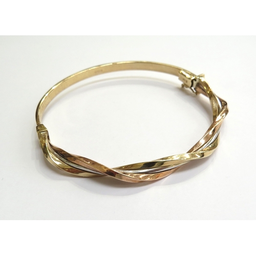 6004 - A 9ct three tone gold hinged bangle, 6cm x 5.8cm, 5.9g