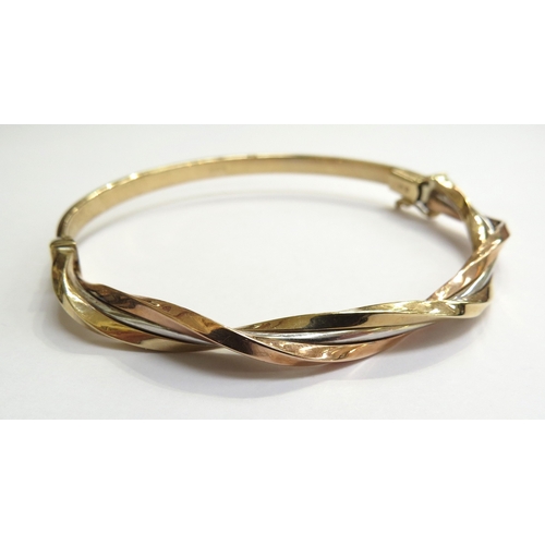 6004 - A 9ct three tone gold hinged bangle, 6cm x 5.8cm, 5.9g