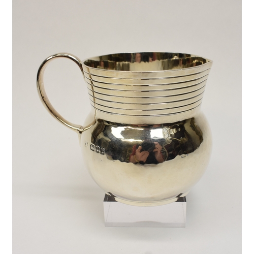 8046 - A Theodore Rossi silver cream jug with banded neck, London 1918, base marked Rossi Norwich.  186g