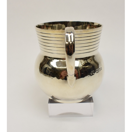 8046 - A Theodore Rossi silver cream jug with banded neck, London 1918, base marked Rossi Norwich.  186g