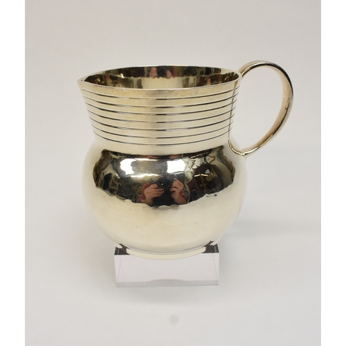 8046 - A Theodore Rossi silver cream jug with banded neck, London 1918, base marked Rossi Norwich.  186g