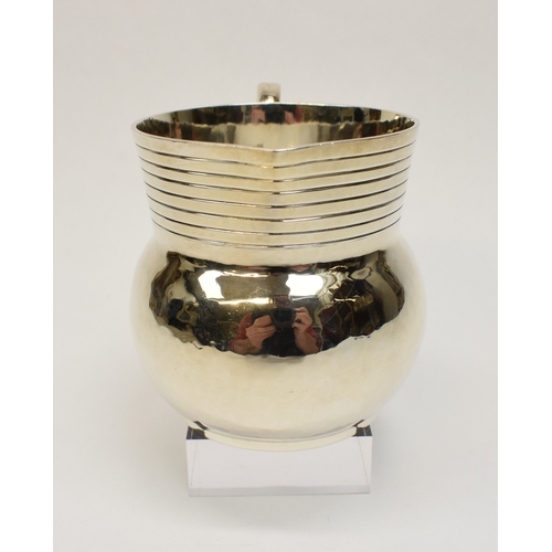 8046 - A Theodore Rossi silver cream jug with banded neck, London 1918, base marked Rossi Norwich.  186g