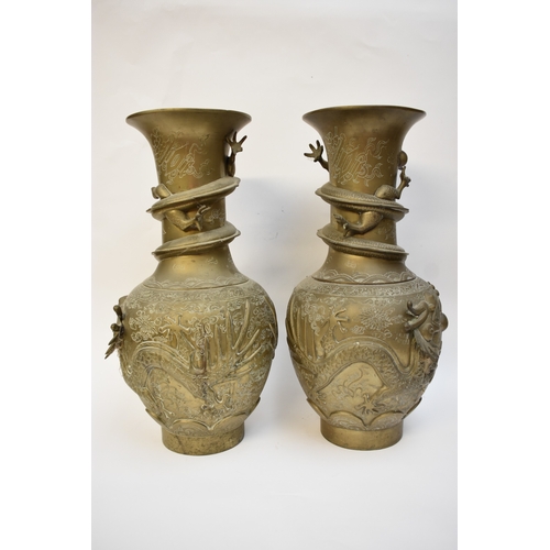 1044 - WITHDRAWN - Circa 1900 a pair of Chinese brass urns with high relief Dragons chasing the flaming pea... 