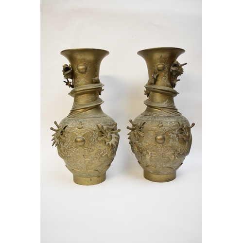 1044 - WITHDRAWN - Circa 1900 a pair of Chinese brass urns with high relief Dragons chasing the flaming pea... 