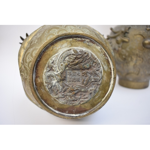 1044 - WITHDRAWN - Circa 1900 a pair of Chinese brass urns with high relief Dragons chasing the flaming pea... 