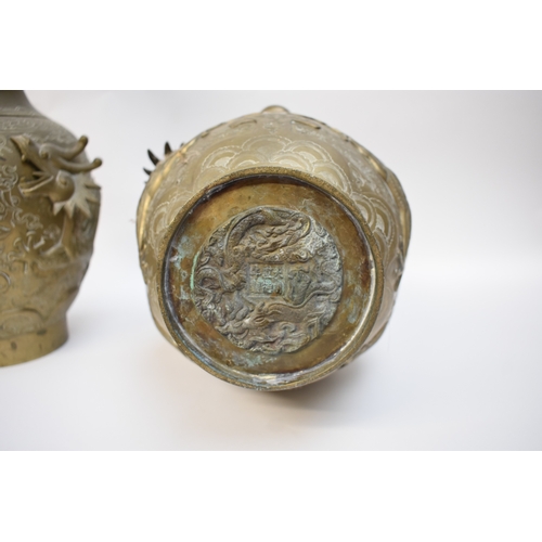 1044 - WITHDRAWN - Circa 1900 a pair of Chinese brass urns with high relief Dragons chasing the flaming pea... 