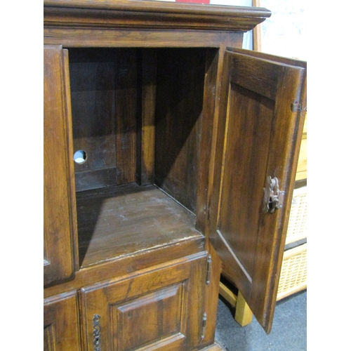 1050 - A panelled oak four door tallboy on sledge feet (with key) 123cm tall x 105cm wide x 63cm deep