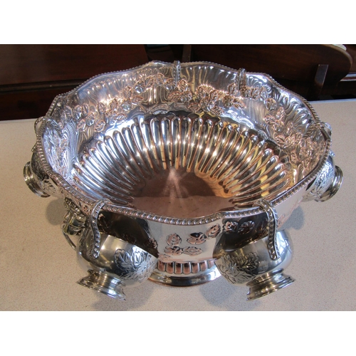 1021 - A silver on copper punch bowl with six cups, lion mask ring handles, foliate and melon fluted design... 
