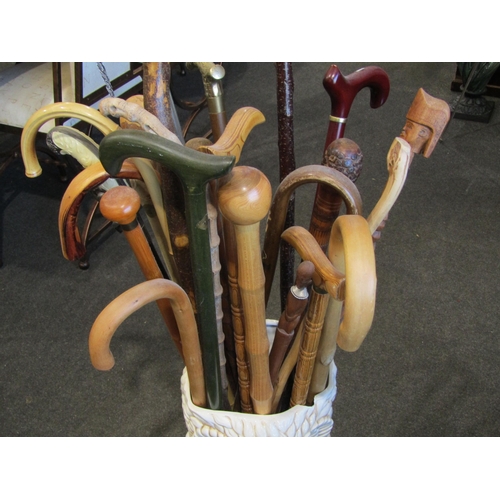 1024 - A ceramic owl form stick stand (large chip) containing a quantity of assorted walking sticks includi... 
