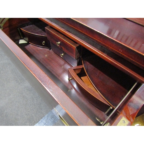 1034 - A campaign style mahogany secretaire chest, drop-flap with fitted interior over three long drawers, ... 