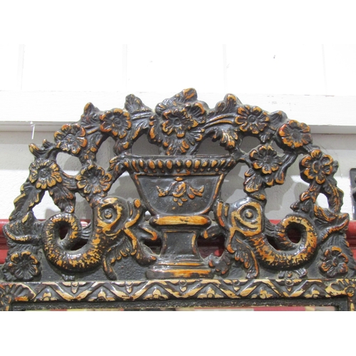 1038 - A late 19th Century wall hanging painted wood effect wall mirror, the top surmounted by dolphin and ... 